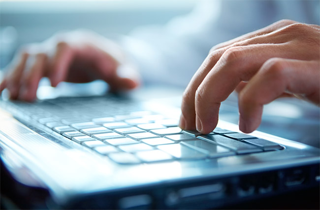 Hands typing on computer keyboard